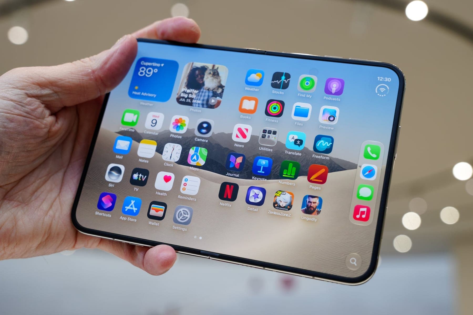 The iPhone Duo held open in one hand, showing its home screen.