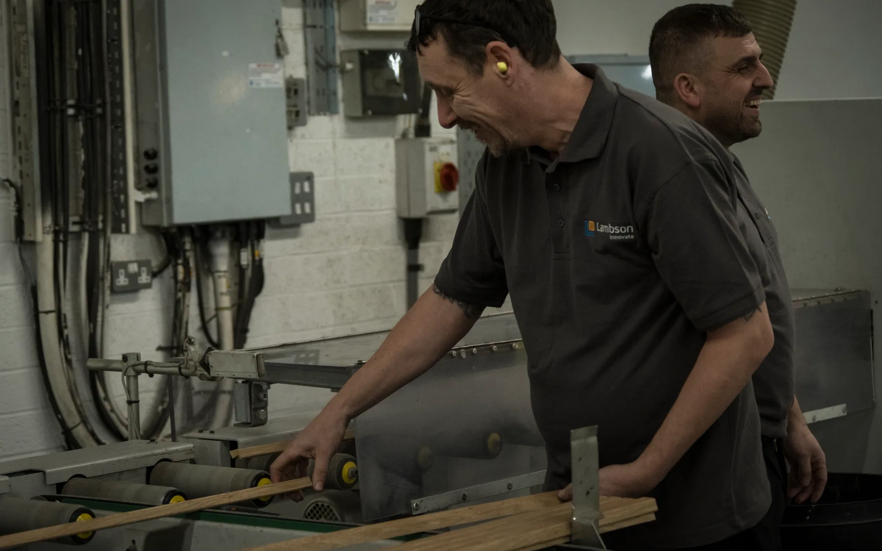 Two of the team working a length of timber at the bench