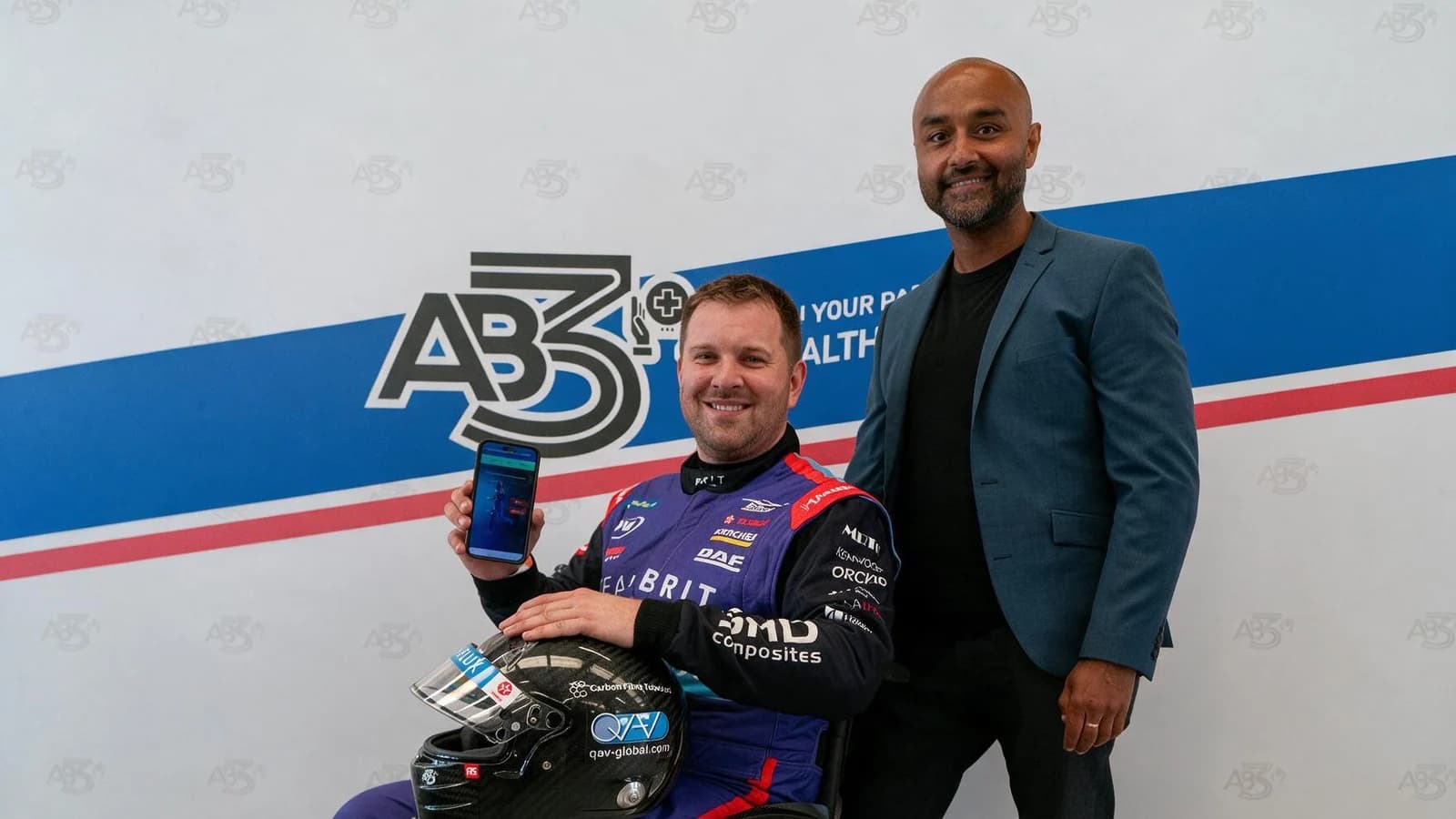 A Team BRIT driver holding the AB3 app, with Ronnie Banerjee