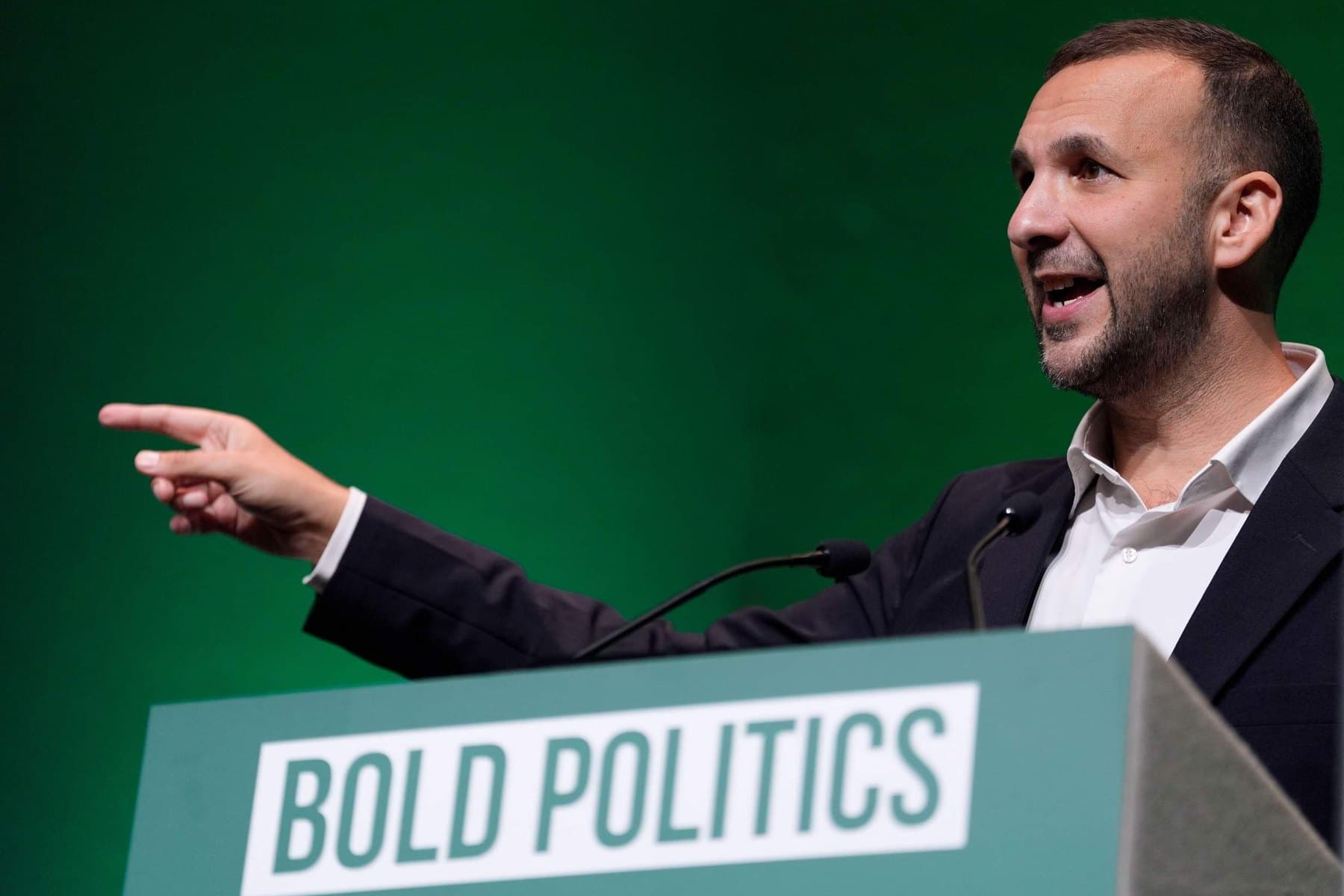Green Party leader Zack Polanski speaking at a podium marked Bold Politics.