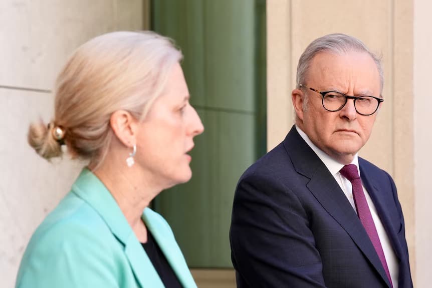 Finance Minister Katy Gallagher speaking at a press conference while Prime Minister Anthony Albanese looks on.